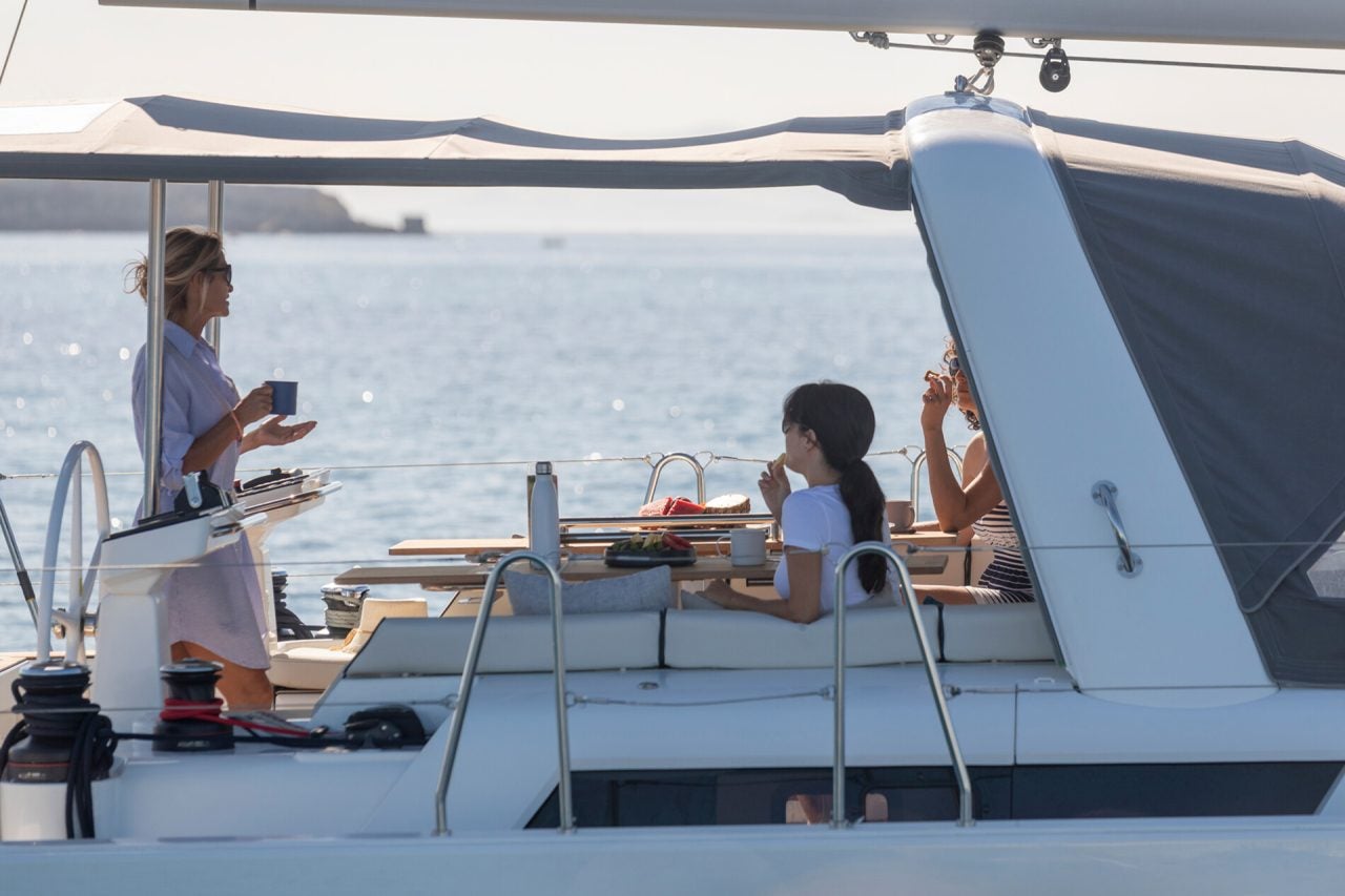 Una personas en el puente de mando del monocasco Oceanis Yacht 54