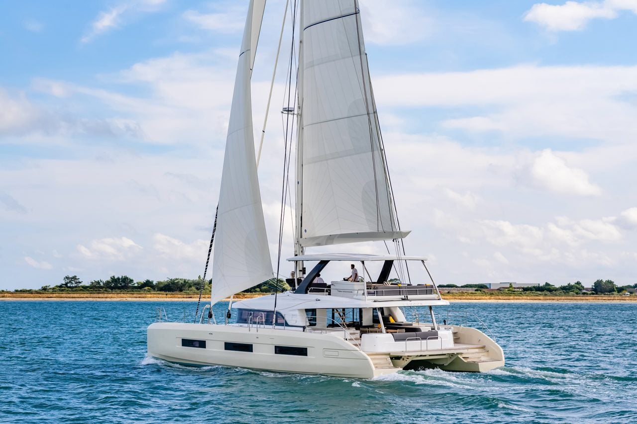 Elegante barca a vela Lagoon 65 in navigazione vicino alla costa