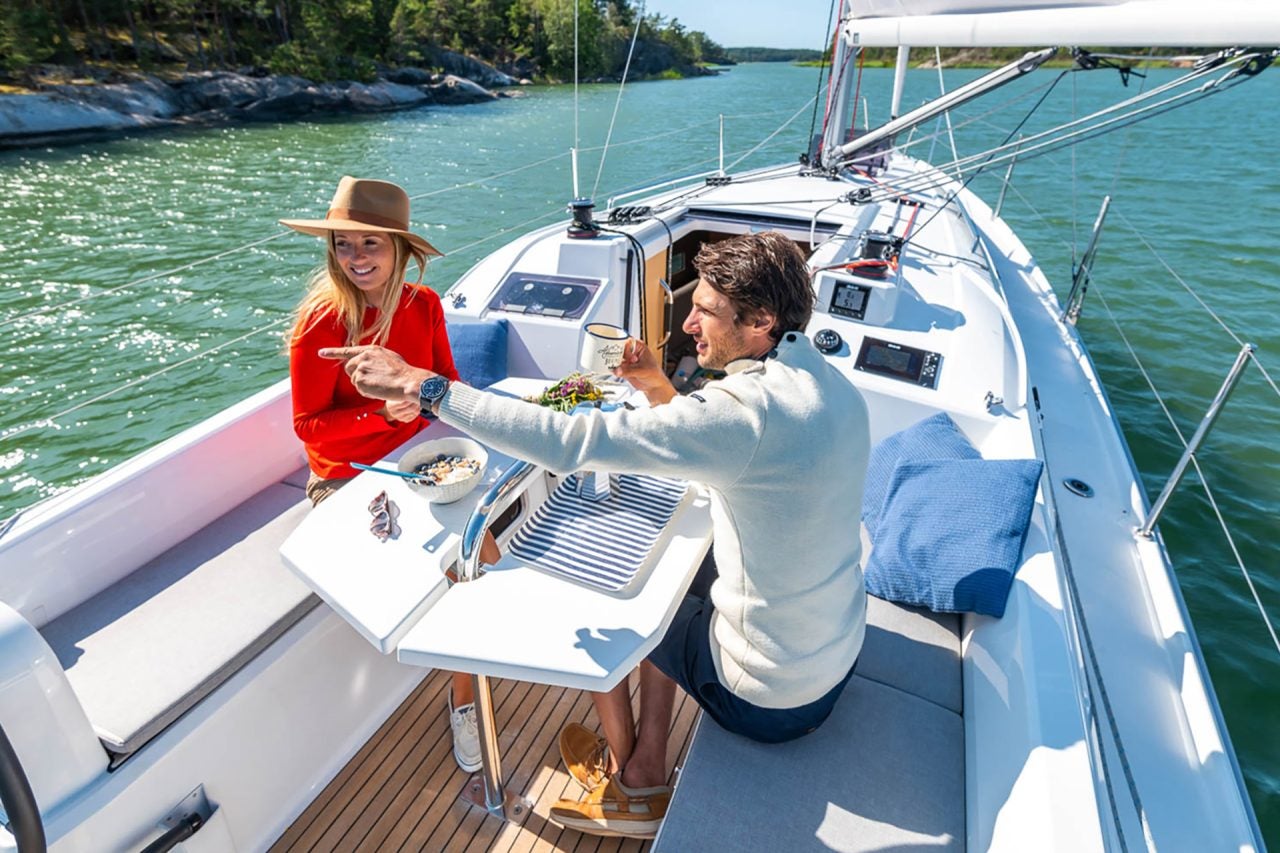 Ein Paar sitzt am Cockpit-Esstisch des Boots Beneteau 30.1