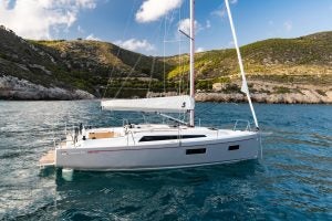 Barca a vela Beneteau 34.1 in rada vicino a una costa panoramica