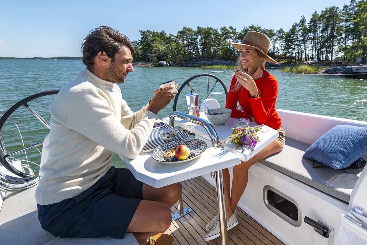 Ein Paar isst am Cockpit-Esstisch des Beneteau 30.1