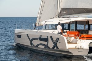 Man at helm sailing the Excess 14 catamaran