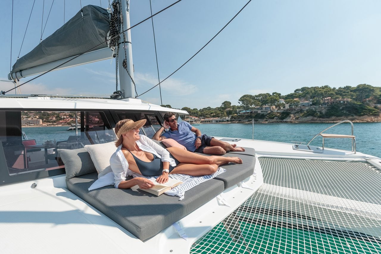 Coppia sul lettino prendisole di prua del catamarano Fountaine Pajot Isla 40